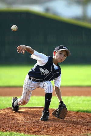 youth baseball player pitching the ball