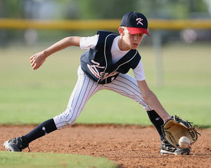 youth baseball player fielding the ball